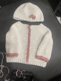 a white knitted jacket and hat on a table