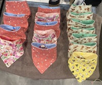 a table with a variety of bibs and bandanas on it